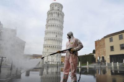 Рабочий проводит санитарные операции в связи с чрезвычайной ситуацией с коронавирусом рядом с Пизанской башней в Пизе, Италия. 17 марта 2020 года. Фото © Getty Images / Laura Lezza